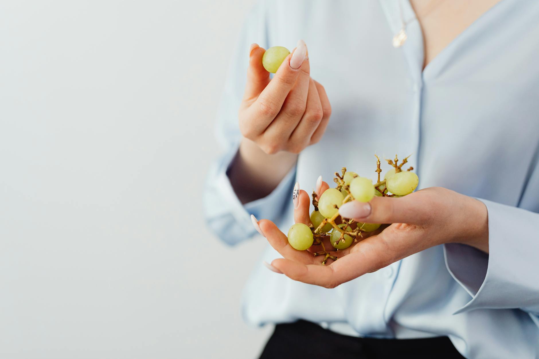 selective focus of a person holding green grapes